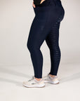 Person wearing navy leggings with a textured pattern on a white background