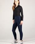 Woman wearing a black long-sleeve top and navy leggings on a white background