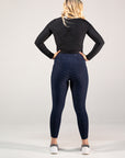 Person wearing navy leggings and a black long-sleeve top with a logo on a white background